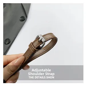 Detail of adjustable leather strap with silver buckle and fine stitching on leopard bag