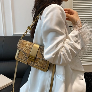 Vintage snake print patchwork handbag with gold chain strap shown on a model