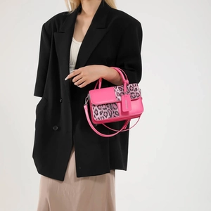 Hot pink leopard print crossbody bag with round handle and adjustable shoulder strap