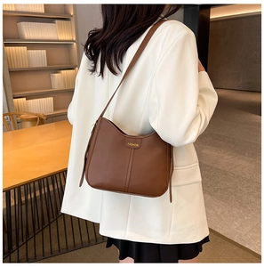 Detailed shot of a brown PU leather hobo bag with gold fashion lettering and slim strap