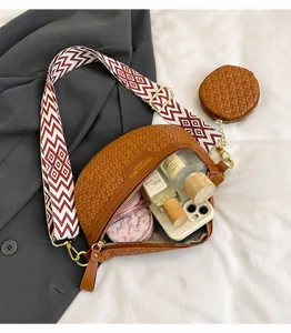 Brown woven crescent bag with wide shoulder strap and matching round coin purse detail