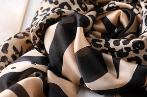 Detailed macro view showing the glossy texture and leopard print silk-like fabric scarf