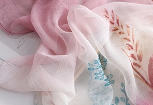 Detail of soft pink gradient chiffon scarf with elegant brown leaf patterns