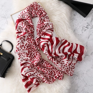 Red silk-like scarf featuring wild leopard and zebra prints on a white plush background