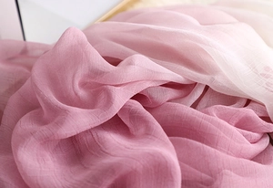 Detail of pink gradient lightweight shawl showing delicate pleated texture and soft fabric
