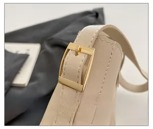 Macro shot of high-quality gold square buckle on a beige vintage leather tote bag