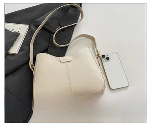 Detail of cream PU leather tote bag with gold fashion plaque and adjustable strap