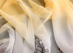 Detail of elegant gradient silk scarf featuring black floral prints and breathable texture