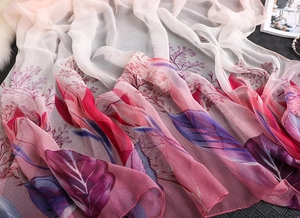 Detail of gradient pink floral chiffon scarf with elegant leaf print and soft texture