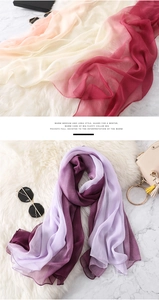 Dettaglio di eleganti sciarpe in chiffon sfumato nei toni del rosso e del viola drappeggiate