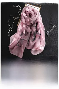 Détail d'une écharpe en soie rose-violette avec motifs floraux 3D et texture légère