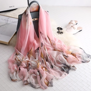 Elegant pink floral silk shawl with lightweight fabric draped over a stylish handbag
