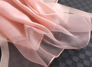 Nahaufnahme von rosa Seidenschal mit glänzenden Pailletten und feiner Textur