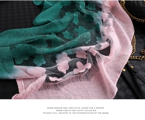 Détail d'une écharpe en soie dégradée avec broderie florale et franges sur fond sombre