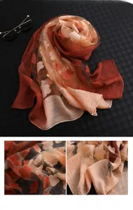 Détails de l'élégant foulard en soie orange dégradé avec motif jacquard et franges