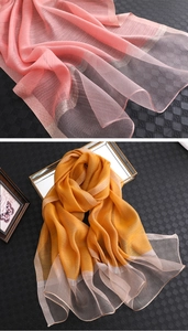 Detail eines Seidenschals mit vertikalen Falten und metallischen Jacquard-Bordüren in Rosa und Gelb