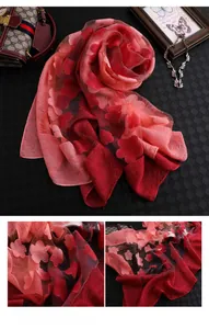 Détail d'une écharpe élégante en soie dégradé rouge avec broderies florales en relief