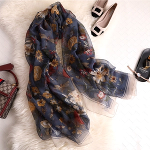 Detail of elegant floral long scarf with dragonfly prints and navy silk-like texture