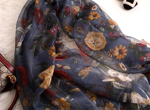 Detail of vintage floral print scarf with butterflies and dragonflies on soft fabric