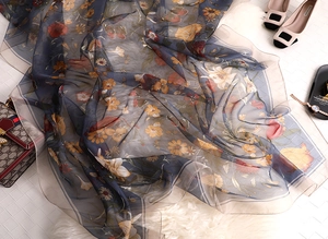 Detail of a vintage floral silk scarf in navy blue with sunflowers and lilies