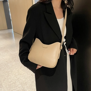 Minimalist beige hobo crossbody bag for women with decorative stitching in a modern style