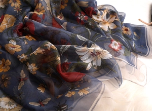 Detail of silk scarf with botanical flower prints and beetles on a soft plush background