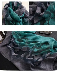 Détail de la broderie florale 3D sur une écharpe en soie légère avec un dégradé