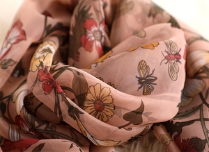 Detail of soft pink floral scarf with bee prints in lightweight chiffon material