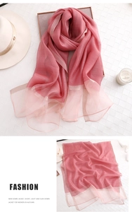 Detail eines rosa Seidenschals mit Farbverlauf und feinen Jacquard-Kanten und Textur