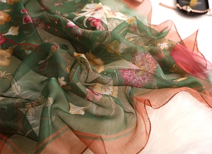 Detail of sheer retro floral silk scarf with lily print on white plush background