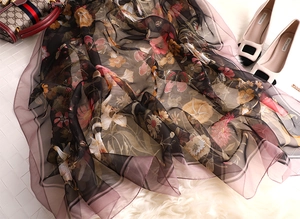 Detail of translucent black silk scarf featuring lily camellia flowers and butterfly patterns