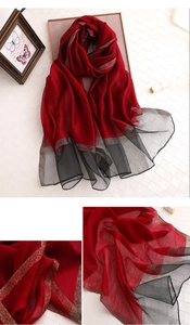 Details des eleganten rot-schwarzen Seidenschals mit glitzernden Goldfäden und Textur