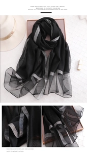 Detailansicht eines schwarzen Seidenschals mit silbernem Jacquardmuster und Textur
