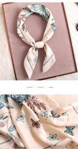 Detailed close-up of floral and butterfly print on elegant satin silk scarf with texture