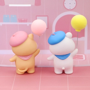 Detail view of cute cat and bear figurines with balloons for birthday cake decoration