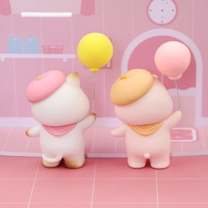 Detail of cute cat and pig cake toppers with berets and balloons for party decor
