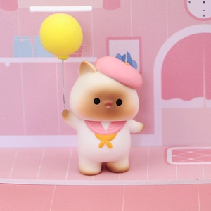 Close-up of a cute cat cake topper with pink beret and yellow balloon for party decor