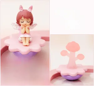 Detail of pink dreamy angel girl figurine with rabbit ears and wings for desktop decor