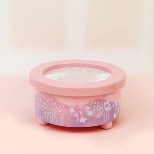 Detailed view of pink music box with romantic floral illustrations and transparent window