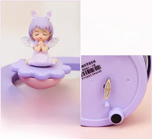 Detail of the mechanical wind-up mechanism on the base of the purple angel music box