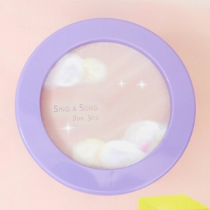 Close-up of a purple dreamy music box featuring starry clouds and Sing a Song text
