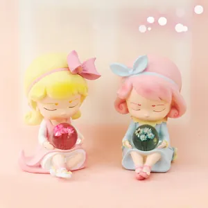 Detailed view of two cute resin girl figurines holding glowing flower globes for desk decor