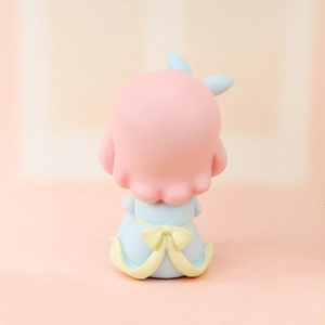 Rear view of a cute resin doll figurine with pink hair and a blue dress for desk decor