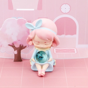 Close-up of cute girl resin night light figurine holding transparent floral crystal ball