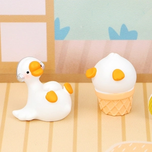 Close-up of cute mini goose figurines with headphones and ice cream cone styling