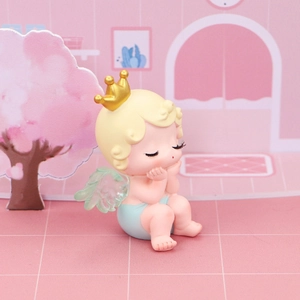 Gros plan d'un petit ange endormi avec couronne dorée et ailes vertes pour gâteaux