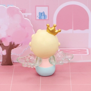 Détail macro d'une figurine d'ange avec ailes transparentes et mini couronne dorée