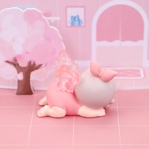 Détail d'une décoration de gâteau ange rose avec ailes dans un décor de cerisiers