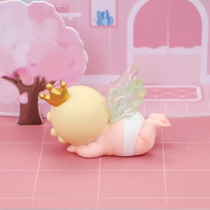 Détail de la figurine d'ange bébé dormant avec couronne dorée et ailes pour décor de gâteau