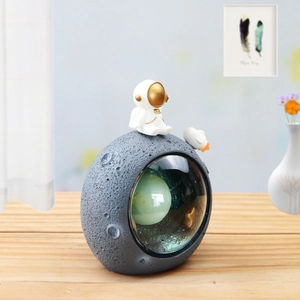 Detail of creative astronaut moon lamp showing resin moon crater texture and mini space pilot